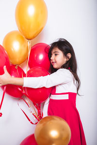 Portrait of a smiling young woman with balloons