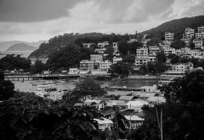 Buildings and river against cloudy sky