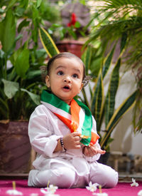 Cute toddler holding indian tricolor flag in traditional cloth with innocent facial expression