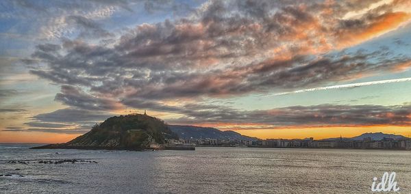 Scenic view of sea against dramatic sky during sunset