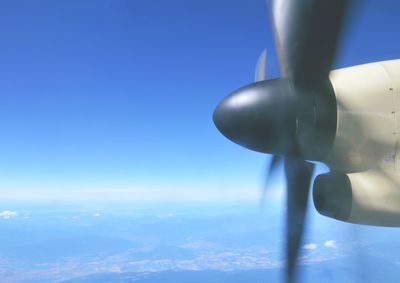 Close-up of airplane wing against clear blue sky