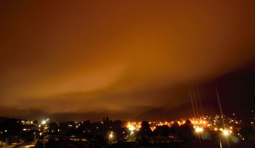 Illuminated buildings in city against sky at night