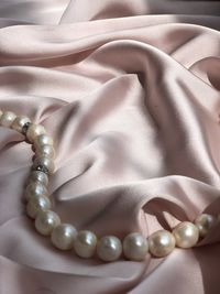 Pearl necklace on pink silk