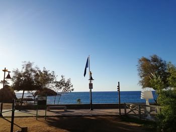 Built structure by sea against clear blue sky