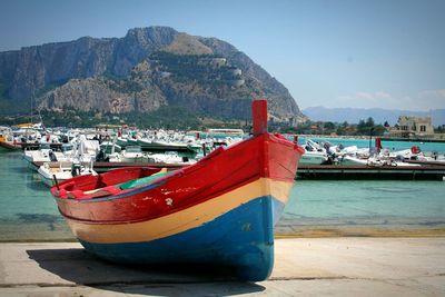 Boats in sea with mountain range in background