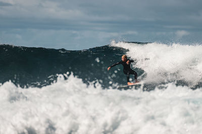 Man surfing waves in atlantic ocean, tenerife, spain