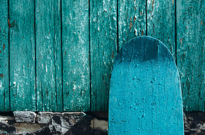 Green wooden skateboard on deteriorated wall on a sunny day. skateboarding background