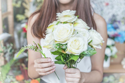 Midsection of woman holding rose bouquet