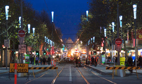 Illuminated road under construction in city at night