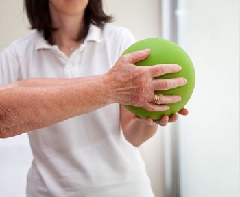 Close-up of women hands holding green ball in gym