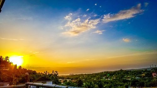 Scenic view of townscape against sky at sunset