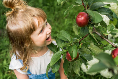 Midsection of woman with berries growing on plant