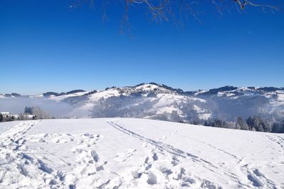 Scenic view of snow mountains against blue sky