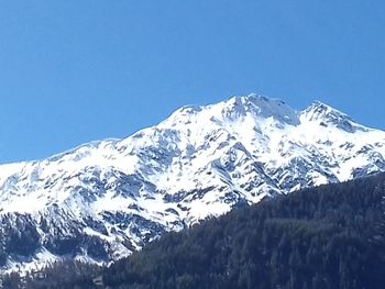 Scenic view of snowcapped mountains against clear blue sky