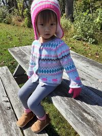 Full length of cute girl sitting on wood