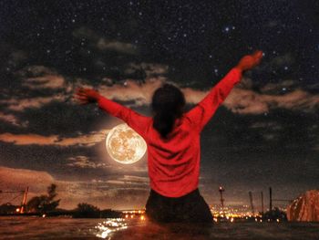 Rear view of person standing in city at night