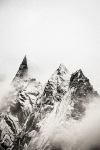 Rock formation by sea against sky during winter