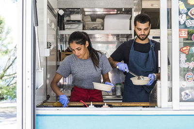 Confident young multi-ethnic male and female colleagues working in food truck