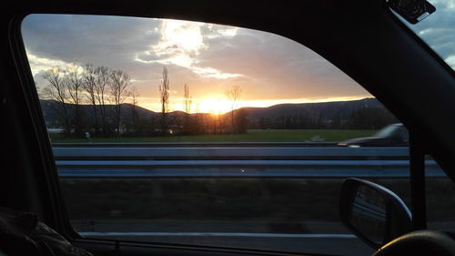 Scenic view of sunset seen through car window