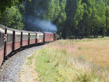 Train on railroad track amidst trees against sky