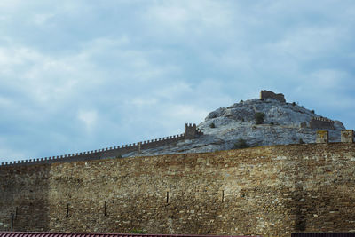 Low angle view of building against cloudy sky