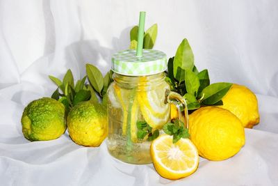 Close-up of lemonade with citrus fruits on table