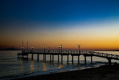 Pier on sea at sunset