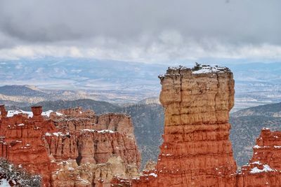 View of rock formation against cloudy sky