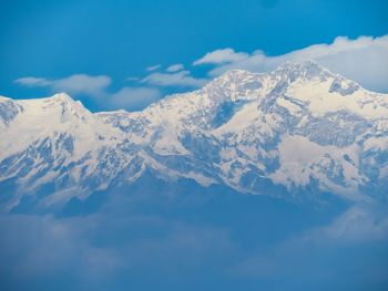 Scenic view of snow mountains against blue sky