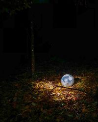 Illuminated lamp on field by building at night