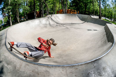 Low section of man with skateboard in park