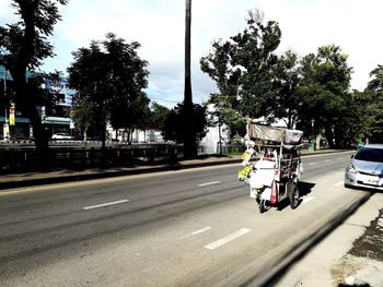 Cars on road against sky in city