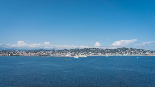 Sailboats in sea against blue sky