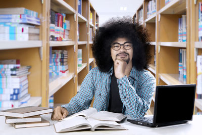 Portrait of young man sitting in library