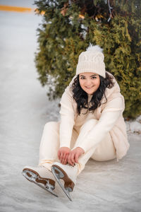 Portrait of young woman sitting on snow