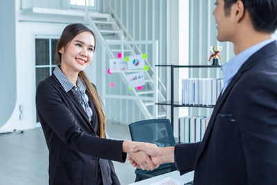 Businessmen shaking hands in office