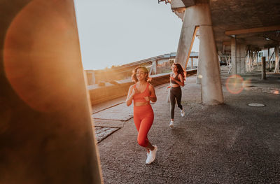 Full length of young woman jogging on sunny day