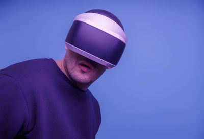 Portrait of man standing against blue background