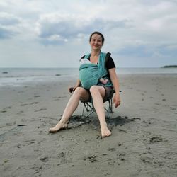 A mother with a baby is sitting on the beach 