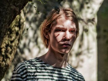 Portrait of mid adult man standing against trees