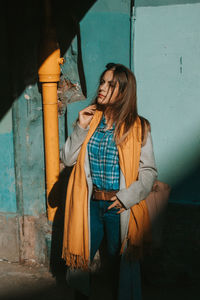 Full length of woman standing against wall