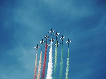 Low angle view of airplane flying against blue sky