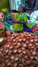 Mature woman selling oil lamp at market