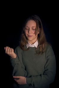 Girl standing against black background