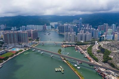 High angle view of city by sea against sky