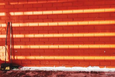 Snow covered brick wall, shadows play and sunlight 