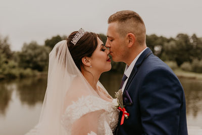 Side view of couple standing against sky