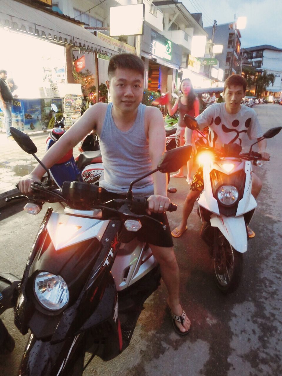 lifestyles, leisure activity, person, casual clothing, sitting, portrait, looking at camera, young adult, happiness, front view, smiling, full length, young men, incidental people, holding, sunlight, outdoors, land vehicle