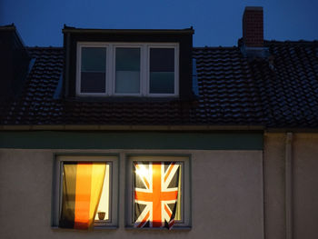 German and english flags on window of house