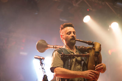 Low angle view of man playing at music concert